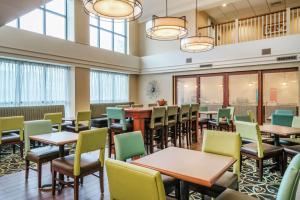 a dining room with tables and chairs and windows at Hampton Inn & Suites Valley Forge/Oaks in Phoenixville