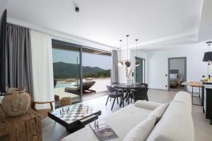 a living room with a white couch and a table at Armante Supreme Villas - Villa Ilianna in Fternón +34 photos