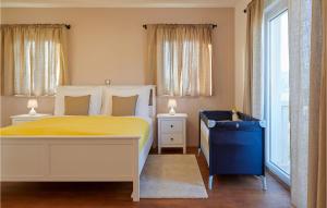 a bedroom with a bed with a yellow bedspread and two windows at Villa 10 Mala Rudina in Rudina