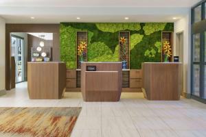 a lobby with a green wall and two counters at Embassy Suites by Hilton Philadelphia Valley Forge in Wayne