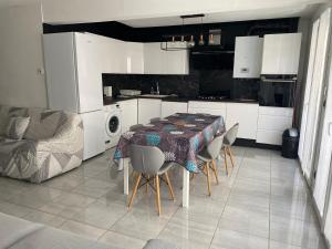 uma cozinha com uma mesa e cadeiras numa cozinha em Super apt Parking + Clim 5 min du centre & gare em Sète