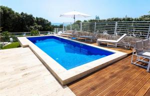 a swimming pool on a wooden deck with an umbrella at Villa Magnolia in Petrcane +16 photos