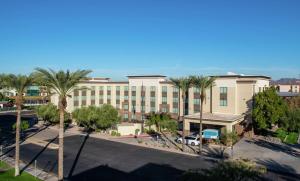 ein großes Gebäude mit Palmen davor in der Unterkunft Hampton Inn Phoenix Airport North in Phoenix