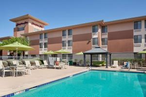 a hotel with a swimming pool and chairs and umbrellas at Hampton Inn Phoenix/Anthem in Anthem