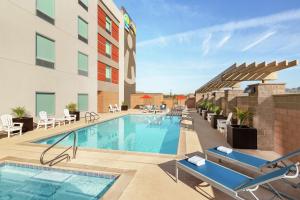 una imagen de una piscina de hotel con sillas y mesas en Home2 Suites By Hilton Scottsdale Salt River en Scottsdale