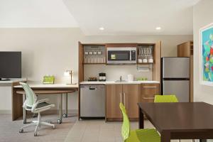 a room with a kitchen with a table and chairs at Home2 Suites By Hilton Scottsdale Salt River in Scottsdale