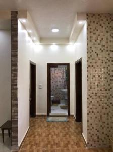 un couloir avec une chambre aux murs blancs et une salle de bains. dans l'établissement Your cozy apartment in Al-Karak, à Al-Karak