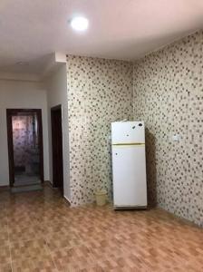 una stanza vuota con un frigorifero bianco di Your cozy apartment in Al-Karak a Kerak