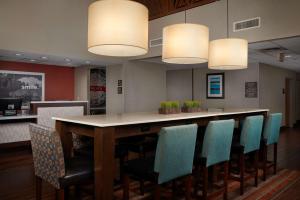 a restaurant with a bar with chairs and lights at Hampton Inn Glendale-Peoria in Peoria