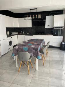 a kitchen with a table and chairs in a kitchen at Super apt Parking + Clim 5 min du centre & gare in Sète