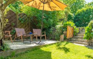 a table and chairs under an umbrella in a garden at Ferienwohnung - Gottsdorf in Gottsdorf