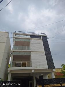 um edifício branco alto com muitas janelas em Hotel BlueSky Ramapuram em Chennai