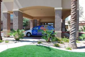 ein blaues Auto, das vor einem Gebäude parkt in der Unterkunft Hampton Inn & Suites Phoenix/Gilbert in Gilbert