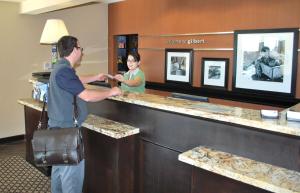 a man and a woman standing at a cash register at Hampton Inn & Suites Phoenix/Gilbert in Gilbert