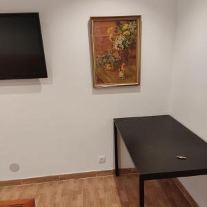 une table noire dans une pièce avec un tableau sur le mur dans l'établissement Pensión CASA LEÓN, à Santoña