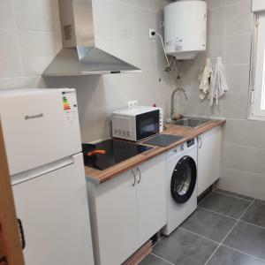 uma cozinha com um frigorífico branco e um micro-ondas em Pensión CASA LEÓN em Santoña