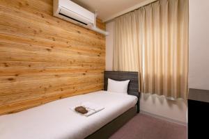 奈良市にあるベーカリーホテル シャトードールの木製の壁のベッドルーム1室(ベッド1台付)