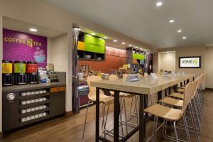 a coffee shop with a bar and chairs in it at Home2 Suites By Hilton Glendale Westgate in Glendale