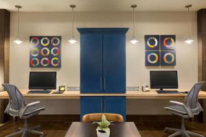 een blauw bureau met 2 computers en 2 stoelen bij Home2 Suites By Hilton Glendale Westgate in Glendale