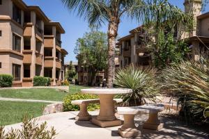 a table and two benches in front of a building at Hilton Vacation Club Scottsdale Links Resort in Scottsdale