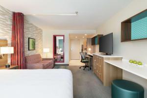 a hotel room with a bed and a desk at Home2 Suites By Hilton Mesa Longbow, Az in Mesa