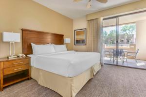 um quarto com uma cama grande e uma varanda em Hilton Vacation Club Scottsdale Links Resort em Scottsdale