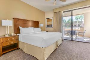 ein Schlafzimmer mit großem Bett und Balkon in der Unterkunft Hilton Vacation Club Scottsdale Links Resort in Scottsdale + 53 Fotos