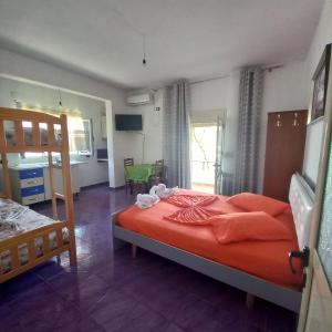 1 dormitorio con 1 cama con sábanas rojas y cocina en Lion's rooms, en Vlorë