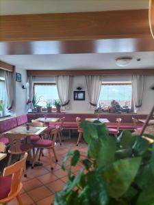 un ristorante con tavoli, sedie e finestre di Hotel Vael a Vigo di Fassa