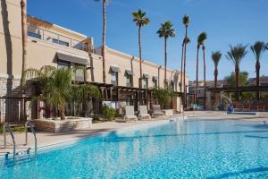 a swimming pool with palm trees in front of a building at Hampton Inn & Suites Scottsdale On Shea Blvd in Scottsdale