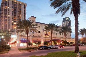 a building with palm trees and cars parked in a parking lot at Hampton Inn & Suites St. Petersburg/Downtown in St Petersburg