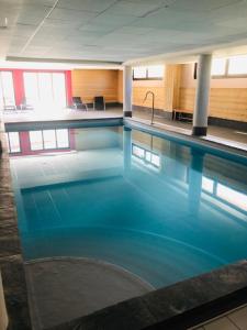 una grande piscina con acqua blu in un edificio di appartement Risoul 1850 résidence Deneb a Risoul