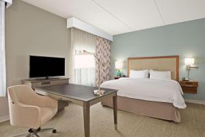 a bedroom with a bed and a desk with a television at Hampton Inn & Suites North Huntingdon-Irwin, PA in Irwin