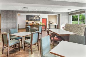 OdessaHampton Inn Odessa Trinity的一间有桌椅和厨房的餐厅