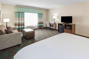 a hotel room with a bed and a flat screen tv at Hampton Inn Bridgeville in Bridgeville