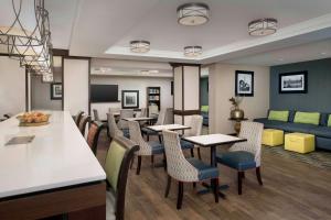 restauracja ze stołami, krzesłami i kanapą w obiekcie Hampton Inn Pittsburgh-Monroeville w mieście Monroeville