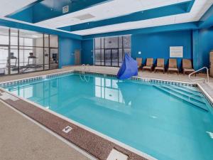 a large swimming pool with blue walls and chairs at Hampton Inn Pittsburgh-Monroeville in Monroeville