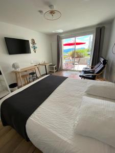 um quarto com uma cama grande e vista para um pátio em FalHappy House em Poisy