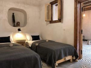 a bedroom with two beds and a mirror at Dar Oki in Marrakesh