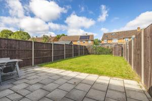 a backyard with a fence and a picnic table at Spacious 4 Bed - Near Uxbridge/Heathrow & PARKING in Slough