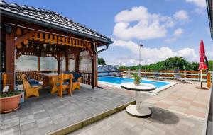 a patio with a table and chairs next to a pool at Beautiful Home In Zasadbreg With Wifi in Zasadbreg