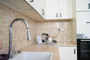 eine Küche mit weißen Schränken und einem Waschbecken in der Unterkunft Ajami Guest House in Tel Aviv