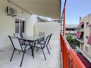 uma mesa preta e cadeiras numa varanda em 2-bedroom Winter Apartment em Atenas