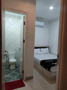 a small bedroom with a bed and a toilet at Cahaya Losmen Sragen in Sragen