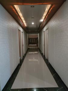 an empty corridor in a building with white walls and ceilings at Cahaya Losmen Sragen in Sragen
