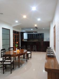 a dining room with a wooden table and chairs at Cahaya Losmen Sragen in Sragen