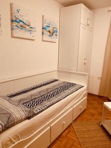 a white room with a bed and a white cabinet at Hiška on the cliff in Ankaran