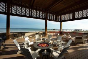 The Lodge at Gulf State Park, A Hilton Hotel في غولف شورز: فناء مع كراسي ومدفأة على الشاطئ