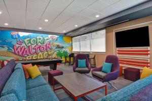 - une salle d'attente avec un canapé bleu et une table de ping-pong dans l'établissement Tru By Hilton Fort Walton Beach, Fl, à Fort Walton Beach