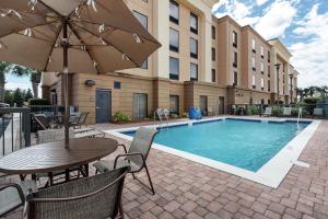 a pool with a table and chairs and an umbrella at Hampton Inn & Suites Navarre in Navarre